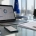 Mesa de trabajo con móvil, documentos legales y ordenador en un contexto de cumplimiento digital empresarial.